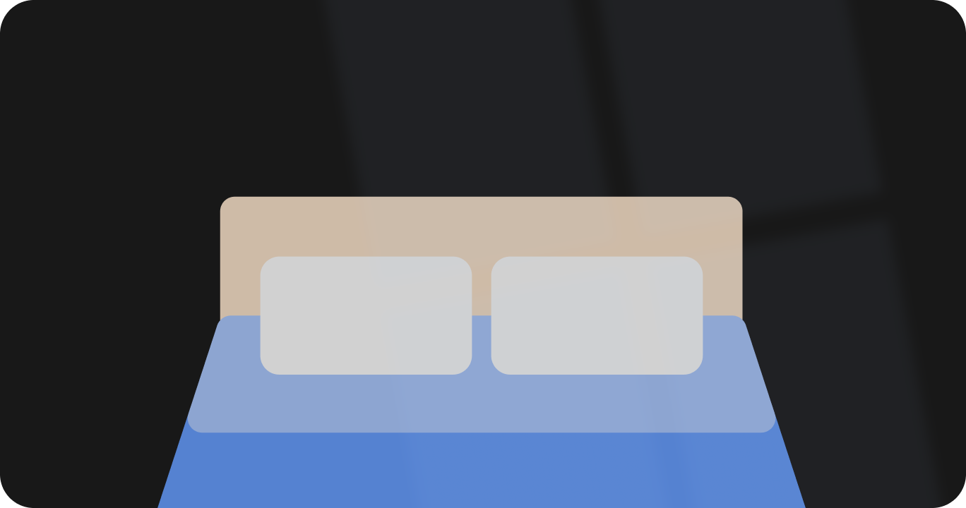 薄暗い光の中にある、落ち着いた雰囲気の寝室と快適なベッド